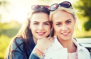 summer vacation, holidays, friendship and people concept - happy smiling young women or teenage girls outdoors. happy young women or teenage girls outdoors