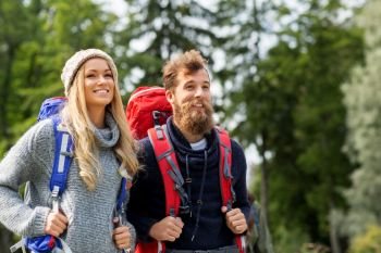 travel, tourism, hiking and people concept - couple of travelers with backpacks outdoors. couple of travelers with backpacks hiking