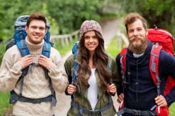 travel, tourism, hiking and people concept - happy friends or travelers with backpacks. happy friends or travelers with backpacks hiking