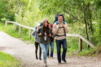 travel, tourism, hiking and people concept - group of happy friends or travelers with backpacks. happy friends or travelers hiking with backpacks