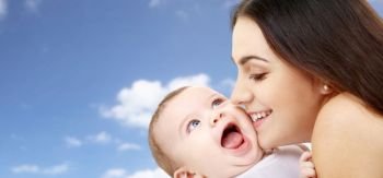 family and motherhood concept - happy smiling young mother with little baby over sky background. mother with baby over sky background