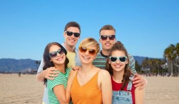 friendship, summer and people concept - group of happy smiling friends in sunglasses hugging over venice beach background in california. friends in sunglasses over white background