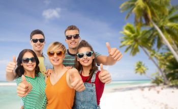 travel, tourism and summer holidays concept - group of happy smiling friends in sunglasses showing thumbs up over tropical beach background in french polynesia. happy friends showing thumbs up
