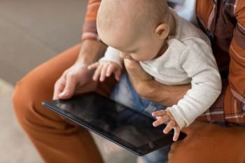 family, technology and people concept - close up of father and baby son with tablet pc. close up of father and baby son with tablet pc