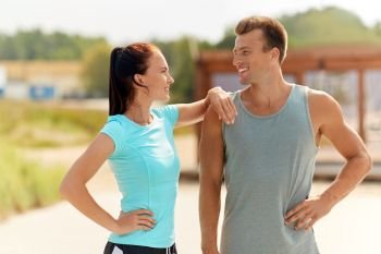 fitness, sport and lifestyle concept - happy couple in sports clothes outdoors. happy couple in sports clothes outdoors