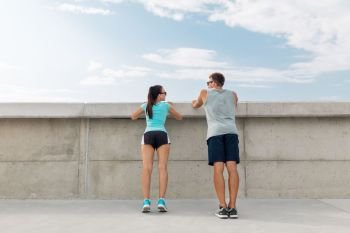 sport, fitness and lifestyle concept - happy couple exercising outdoors. happy couple exercising outdoors