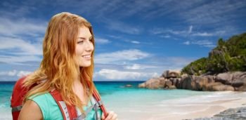 adventure, travel, tourism, hike and people concept - smiling young woman with backpack over background of seychelles island beach in indian ocean. happy woman with backpack over seychelles beach