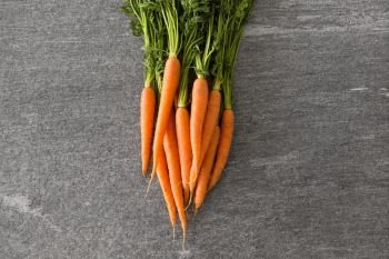 healthy eating, food, dieting and vegetarian concept - close up of carrot bunch on table. close up of carrot bunch on table
