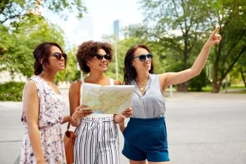tourism, travel and friendship concept - happy women or friends with map on street in summer city. happy women with map on street in summer city