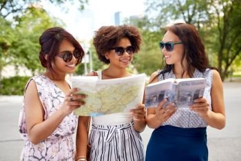 tourism, travel and friendship concept - happy women with city guide and map on street in summer. happy women with city guide and map in summer