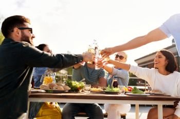 leisure and people concept - happy friends toasting drinks at rooftop party in summer. happy friends toasting drinks at rooftop party