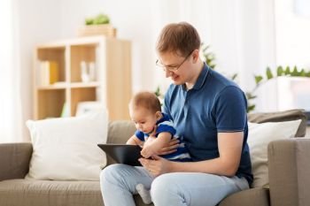 family, technology and fatherhood concept - happy father and little baby son with tablet pc computer at home. happy father and baby son with tablet pc at home