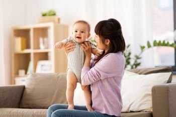 family and motherhood concept - happy smiling young asian mother with little baby son at home. happy young asian mother with little baby at home
