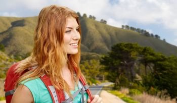 adventure, travel, tourism, hike and people concept - smiling young woman with backpack over big sur of california hills background. smiling woman with backpack on big sur hills