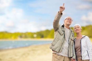 old age, retirement and future concept - happy senior couple over beach background. happy senior couple over beach background