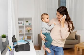 motherhood, multi-tasking, family and technology concept - happy mother with baby calling on smartphone at home. mother with baby calling on smartphone at home