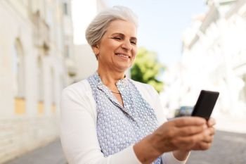 technology, old age and people concept - happy senior woman with smartphone in summer. happy senior woman with smartphone in summer
