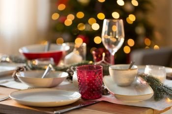 christmas, holidays and table setting concept - glass and tableware for festive dinner at home. table setting for christmas dinner at home