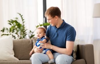 family, fatherhood and people concept - happy father with baby son at home. happy father with baby son at home