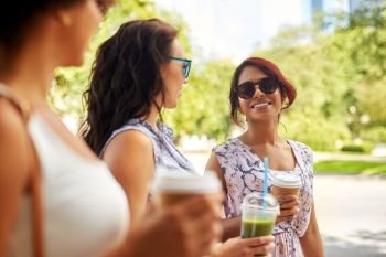 leisure, people and friendship concept - happy women or friends with takeaway drinks talking summer park. happy women or friends with drinks at summer park