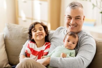 family, fatherhood and people concept - happy father with preteen and baby son at home. happy father with preteen and baby son at home