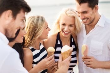friendship, leisure and people concept - group of happy friends in striped clothes eating ice cream. happy friends in striped clothes eating ice cream