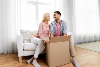 delivery, mail and people concept - happy couple with open parcel box at home. happy couple with open parcel box at home