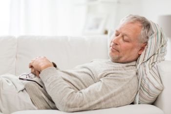 old age, rest, comfort and people concept - senior man sleeping on sofa at home. senior man sleeping on sofa at home