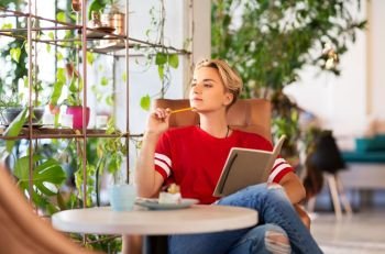 people, leisure and inspiration concept - woman or teenage girl with notebook at coffee shop or cafe. teenage girl with notebook at coffee shop or cafe