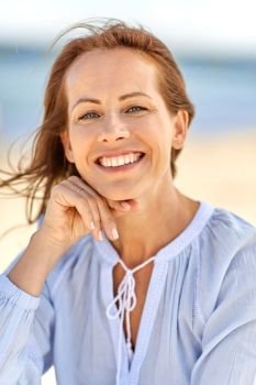people and leisure concept - portrait of happy smiling woman on summer beach. portrait of happy smiling woman on summer beach