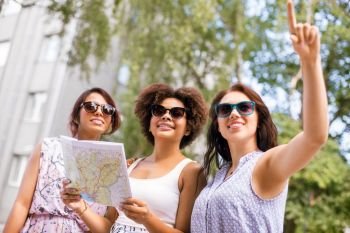 tourism, travel and friendship concept - happy tourist women or friends with map on street in summer city. happy women with map on street in summer city