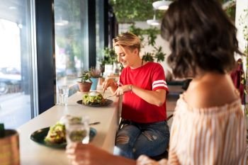 food and people concept - female friends eating at restaurant or cafe. female friends eating at restaurant