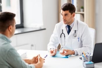 medicine, healthcare and diabetes concept - doctor with glucometer and insulin pen device talking to male patient at medical office in hospital. doctor with glucometer and patient at hospital