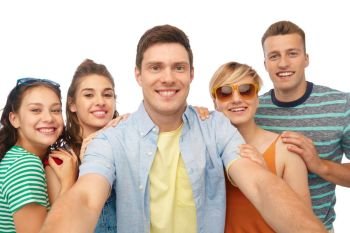 friendship and people concept - group of happy smiling friends taking selfie over white background. happy friends taking selfie over white background