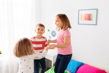 childhood, leisure and family concept - happy children playing at home. happy children playing at home