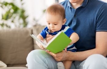 family, parenthood and people concept - happy asian baby boy and father with book at home. baby boy and father with book at home