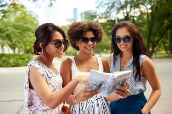 tourism, travel and friendship concept - happy women with city guide on street in summer. happy women with city guide on street in summer