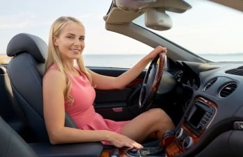 travel, road trip and people concept - happy young woman driving convertible car. happy young woman driving convertible car
