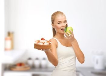 slimming and diet concept - happy woman eating apple instead of cake over home kitchen room background. happy woman eating apple instead of cake