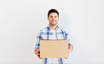 people and moving to new place concept - happy man holding cardboard box. happy man holding cardboard box