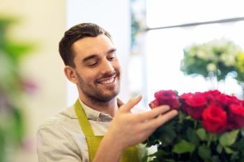 small business, sale and floristry concept - florist or seller setting red roses at flower shop. florist or seller setting red roses at flower shop