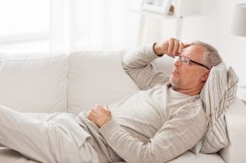 old age, problem and people concept - senior man  lying on sofa and thinking at home. senior man  lying on sofa and thinking at home