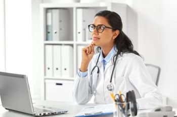 healthcare, technology people and medicine concept - female doctor in white coat with laptop computer and papers at hospital. female doctor with laptop and papers at hospital