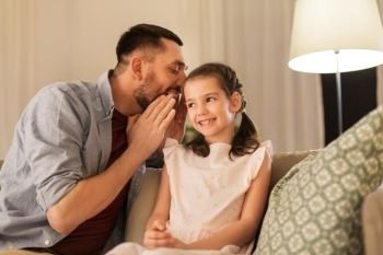 family, fatherhood, leisure and people concept - happy father whispering secret to daughter at home. happy father whispering secret to daughter at home