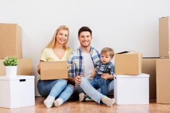 mortgage, people, family and real estate concept - happy mother, father and little son with cardboard boxes moving to new home. happy family with boxes moving to new home
