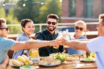 leisure and people concept - happy friends toasting non alcoholic drinks at rooftop party in summer. happy friends toasting drinks at rooftop party