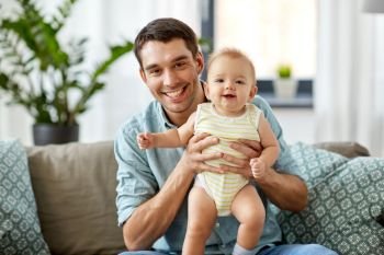family, fatherhood and people concept - father with little baby daughter at home. father with little baby daughter at home