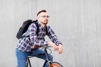 travel, tourism and lifestyle - young hipster man in earphones with fixed gear bike and backpack on city street. hipster man with fixed gear bike and backpack