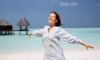 travel, tourism and summer vacation concept - happy smiling woman over exotic tropical beach and bungalow shed background. happy woman over beach and bungalow on background