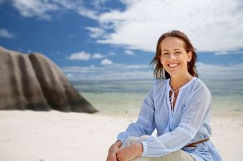 people and summer concept - happy smiling woman over seychelles island tropical beach background. happy woman over seychelles island tropical beach